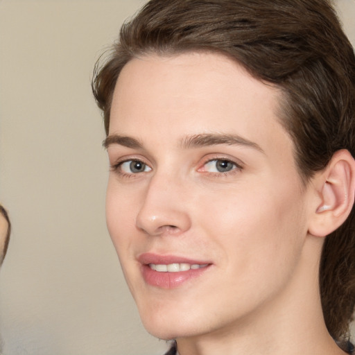 Joyful white young-adult female with medium  brown hair and grey eyes