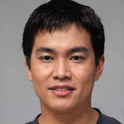 Joyful asian young-adult male with short  black hair and brown eyes