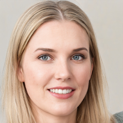 Joyful white young-adult female with long  brown hair and blue eyes