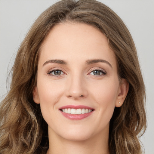 Joyful white young-adult female with long  brown hair and green eyes