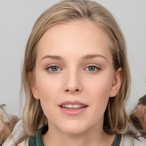 Joyful white young-adult female with medium  brown hair and blue eyes