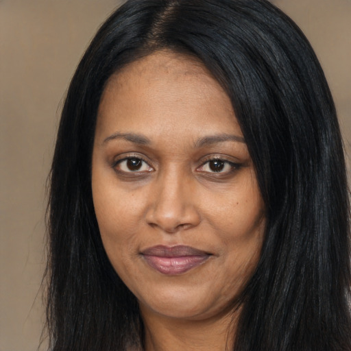 Joyful black adult female with long  black hair and brown eyes