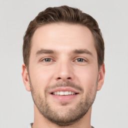 Joyful white young-adult male with short  brown hair and grey eyes