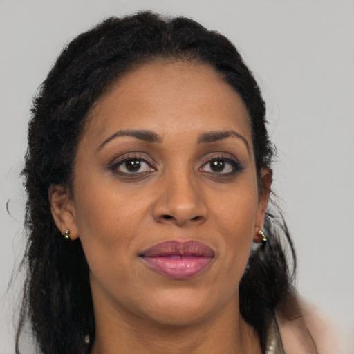 Joyful black adult female with long  brown hair and brown eyes