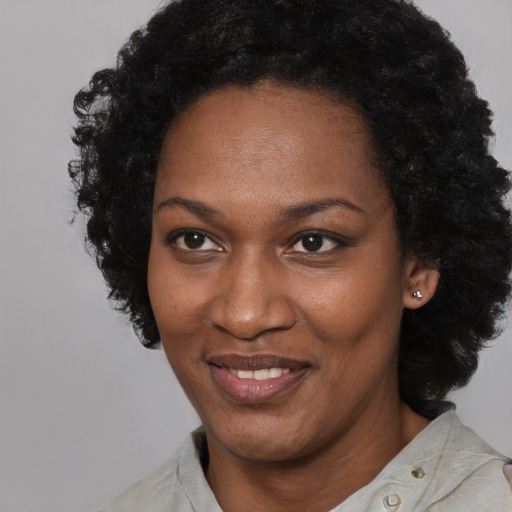 Joyful black adult female with short  black hair and brown eyes