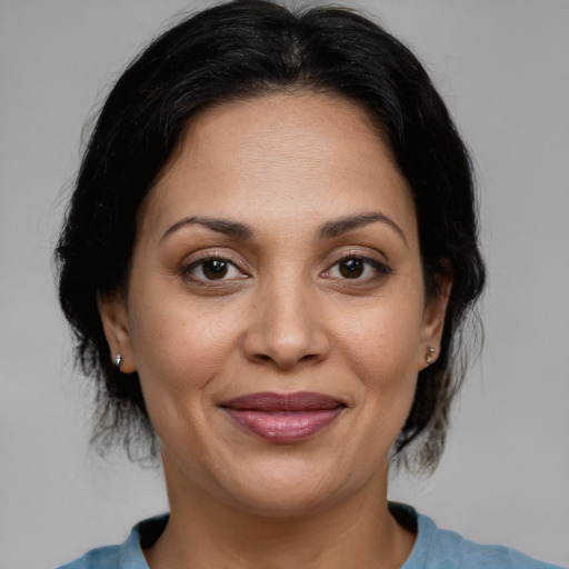 Joyful latino adult female with medium  brown hair and brown eyes