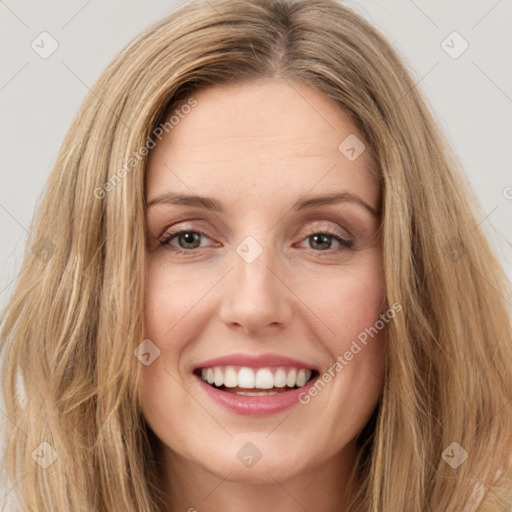 Joyful white young-adult female with long  brown hair and brown eyes