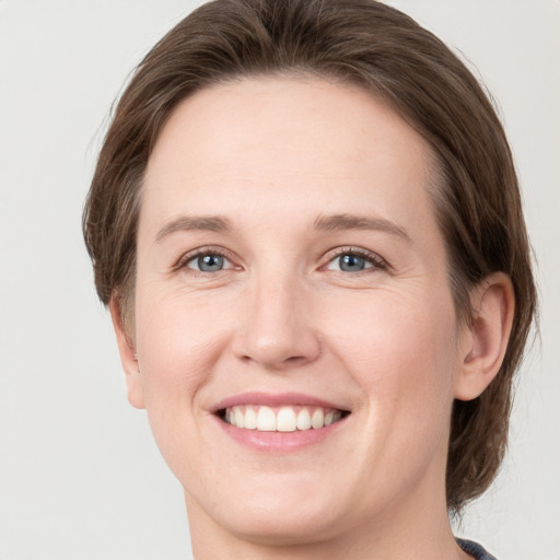 Joyful white young-adult female with medium  brown hair and green eyes