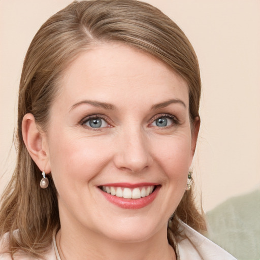 Joyful white young-adult female with medium  brown hair and blue eyes