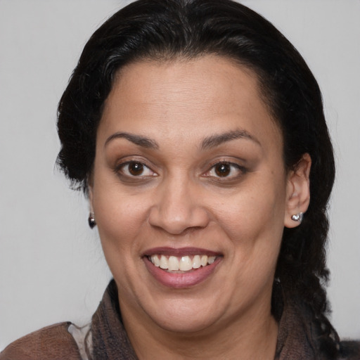 Joyful latino adult female with medium  brown hair and brown eyes