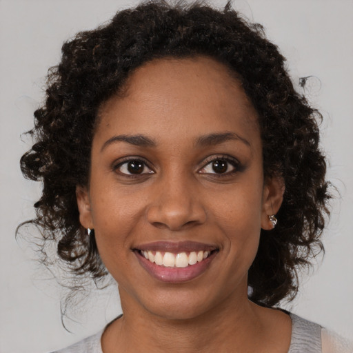 Joyful black young-adult female with medium  brown hair and brown eyes