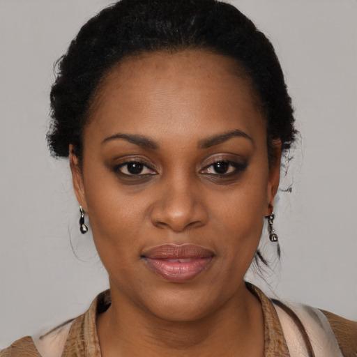 Joyful black young-adult female with long  black hair and brown eyes