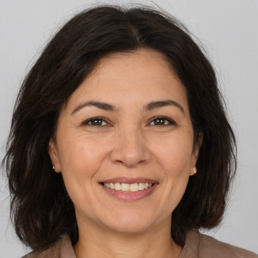 Joyful white adult female with medium  brown hair and brown eyes