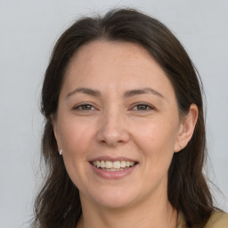 Joyful white adult female with long  brown hair and brown eyes