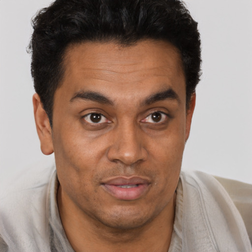 Joyful latino young-adult male with short  brown hair and brown eyes