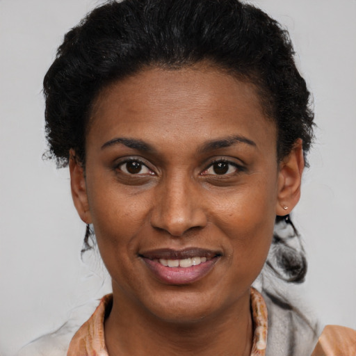 Joyful black young-adult female with short  brown hair and brown eyes