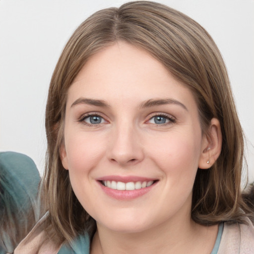 Joyful white young-adult female with medium  brown hair and grey eyes