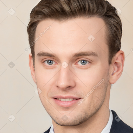 Joyful white young-adult male with short  brown hair and grey eyes