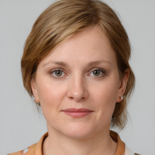 Joyful white young-adult female with medium  brown hair and grey eyes