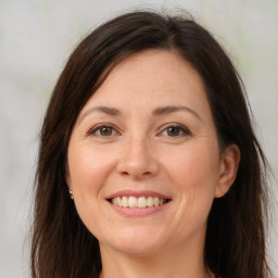 Joyful white adult female with long  brown hair and brown eyes