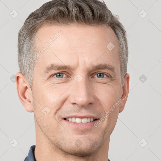 Joyful white adult male with short  brown hair and grey eyes