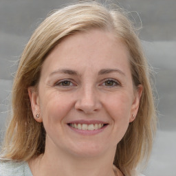 Joyful white adult female with medium  brown hair and grey eyes