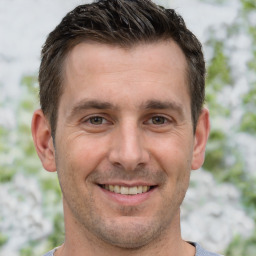 Joyful white adult male with short  brown hair and brown eyes