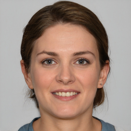 Joyful white young-adult female with medium  brown hair and blue eyes