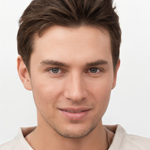 Joyful white young-adult male with short  brown hair and grey eyes