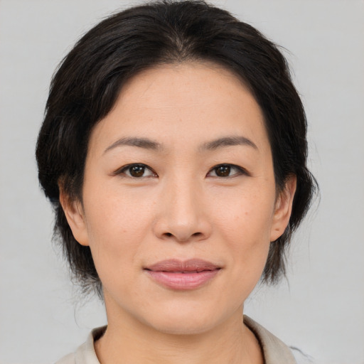 Joyful asian young-adult female with medium  brown hair and brown eyes