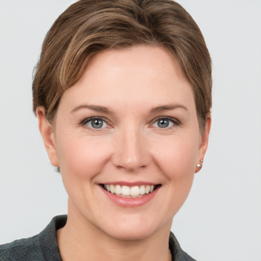 Joyful white young-adult female with short  brown hair and grey eyes