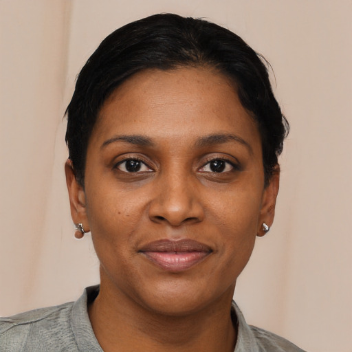 Joyful black young-adult female with short  black hair and brown eyes