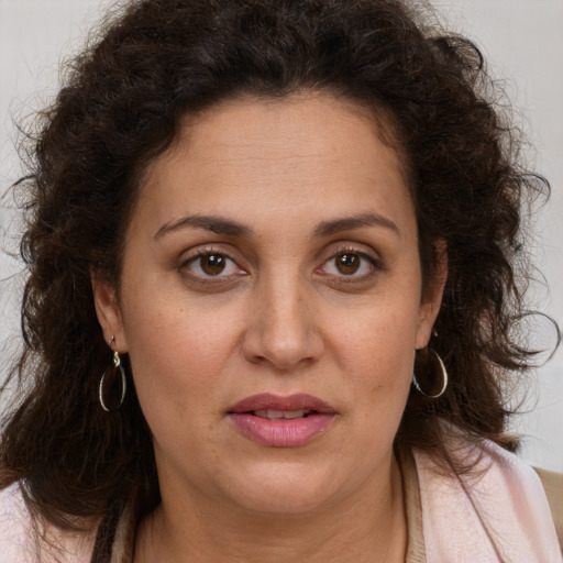 Joyful white adult female with long  brown hair and brown eyes