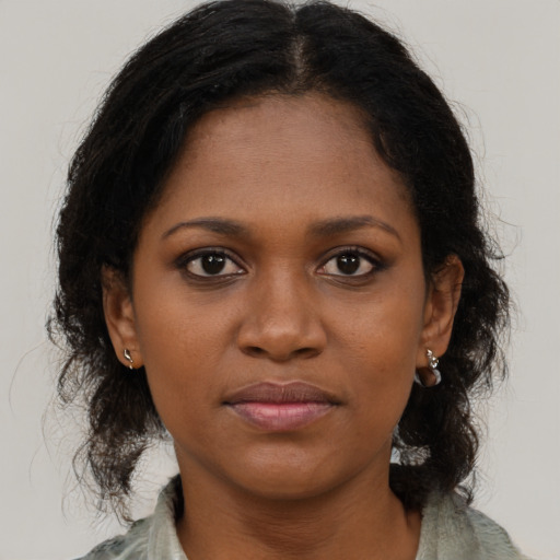 Joyful black young-adult female with medium  brown hair and brown eyes