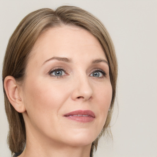 Joyful white adult female with medium  brown hair and grey eyes