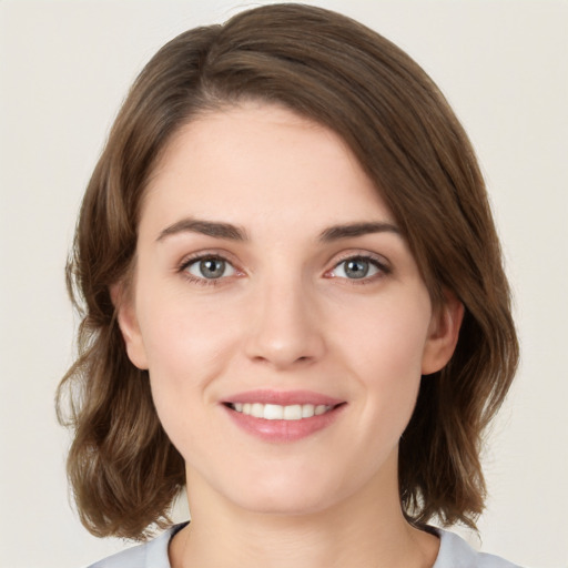 Joyful white young-adult female with medium  brown hair and green eyes