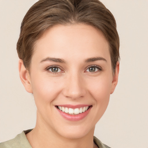 Joyful white young-adult female with short  brown hair and grey eyes