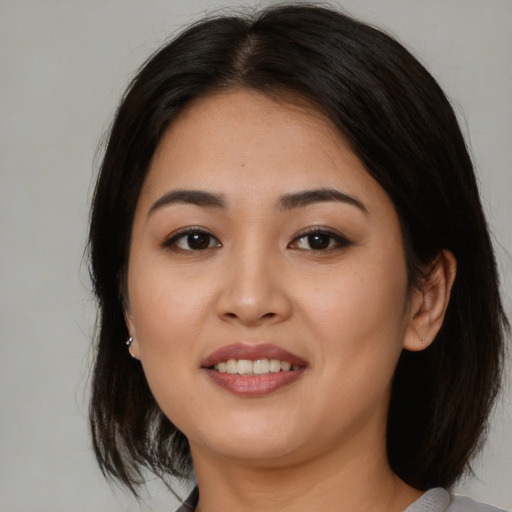 Joyful asian young-adult female with medium  brown hair and brown eyes