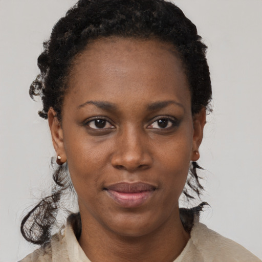 Joyful black young-adult female with short  black hair and brown eyes