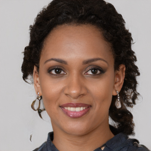 Joyful black young-adult female with medium  brown hair and brown eyes