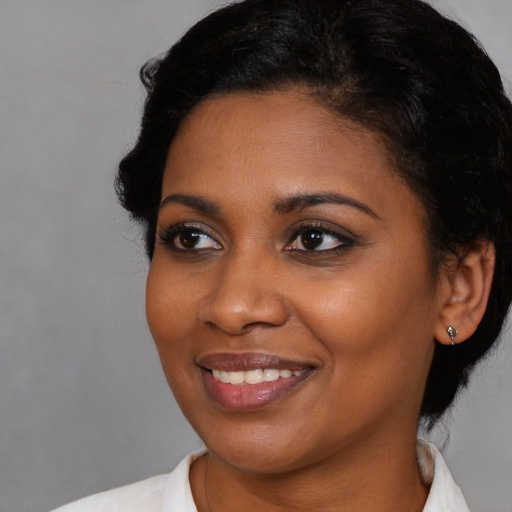 Joyful black young-adult female with medium  black hair and brown eyes