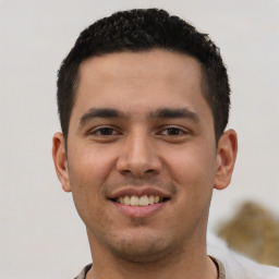 Joyful latino young-adult male with short  black hair and brown eyes