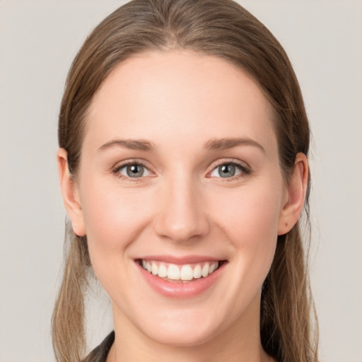 Joyful white young-adult female with long  brown hair and blue eyes