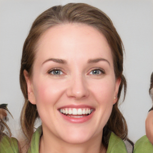 Joyful white young-adult female with medium  brown hair and blue eyes