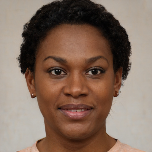 Joyful black young-adult female with short  brown hair and brown eyes