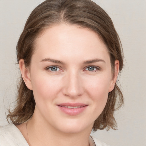 Joyful white young-adult female with medium  brown hair and blue eyes