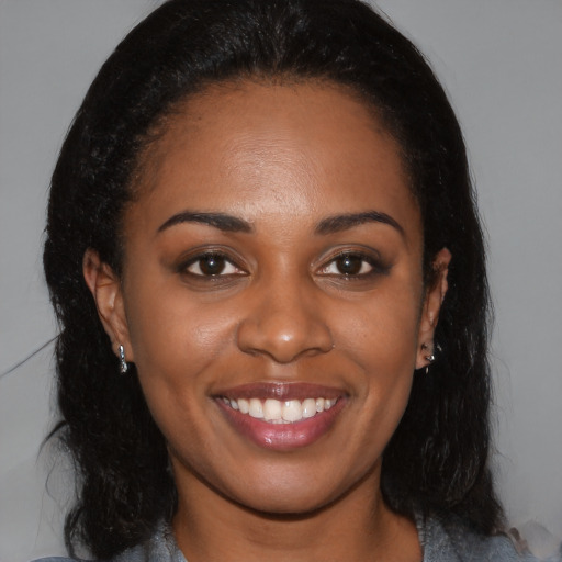 Joyful black young-adult female with long  brown hair and brown eyes