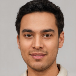 Joyful latino young-adult male with short  black hair and brown eyes