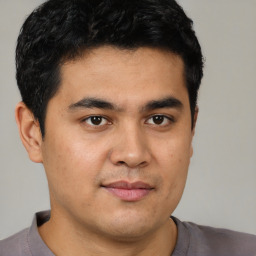 Joyful latino young-adult male with short  brown hair and brown eyes