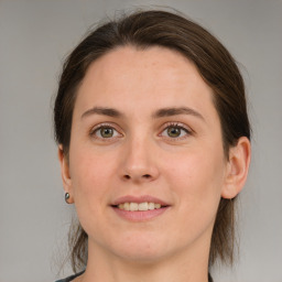 Joyful white young-adult female with medium  brown hair and green eyes